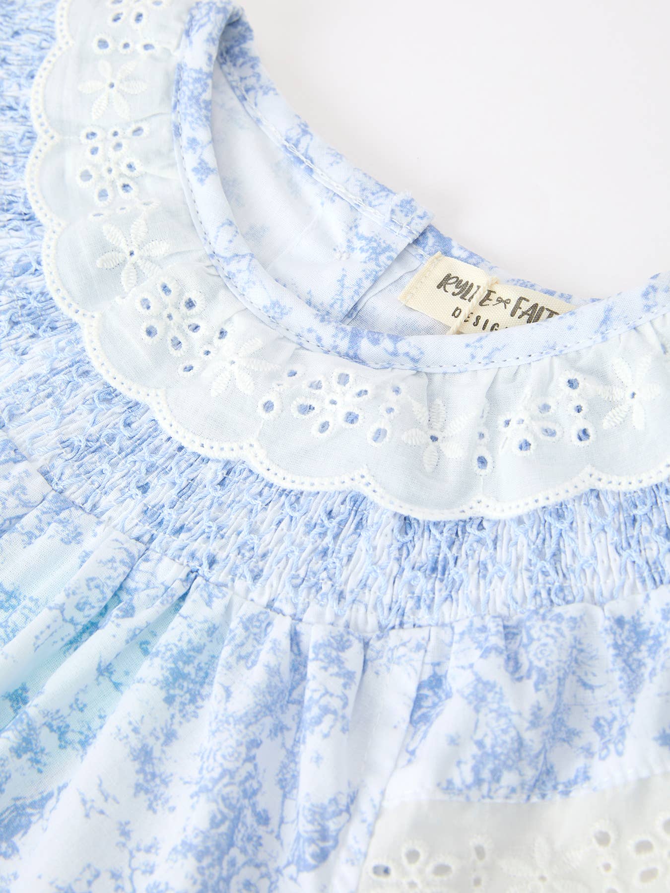 Blue Floral Smocked Matching Set Baby Romper showing finished with hand-smocked detailing across the chest