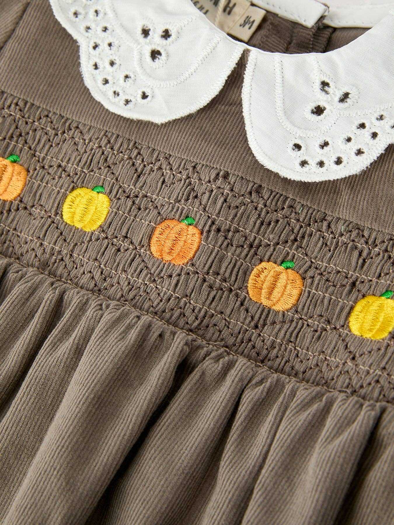 Pumpkin Smocked Eyelet Collar Romper showing white eyelet peter pan collar