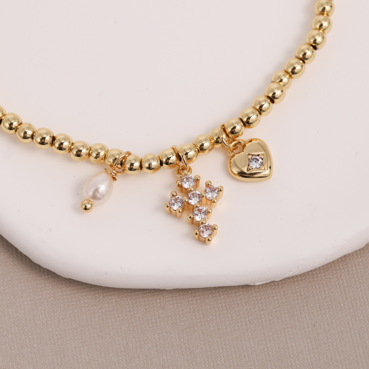 Gold Cross and Heart Charm Beaded Stretch Bracelet showing 18K gold-plated