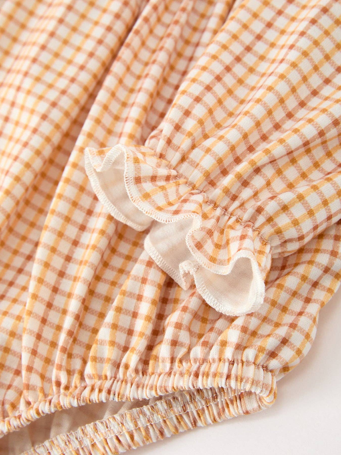 Orange Plaid Floral Bubble Romper showing ruffled cuffs
