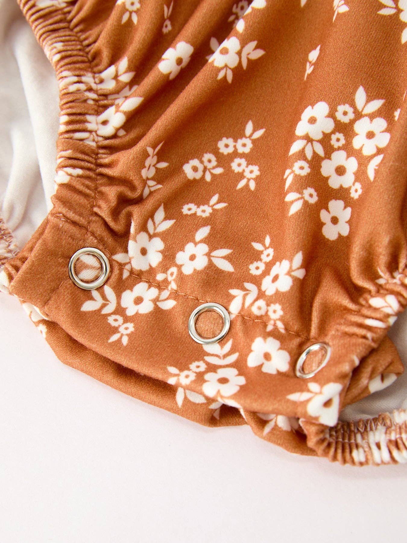 Rust Floral Bubble Romper showing long sleeves with ruffle cuffs
