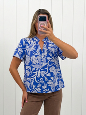 AI-assisted FASHN try-on of Blue Floral Split Neck Ruffle Top on boutique owner.