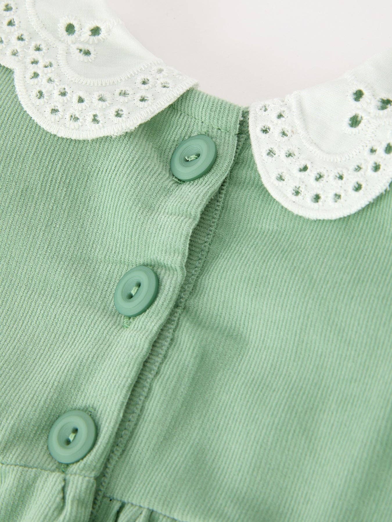 Green Smocked Floral Romper showing delicate floral applique