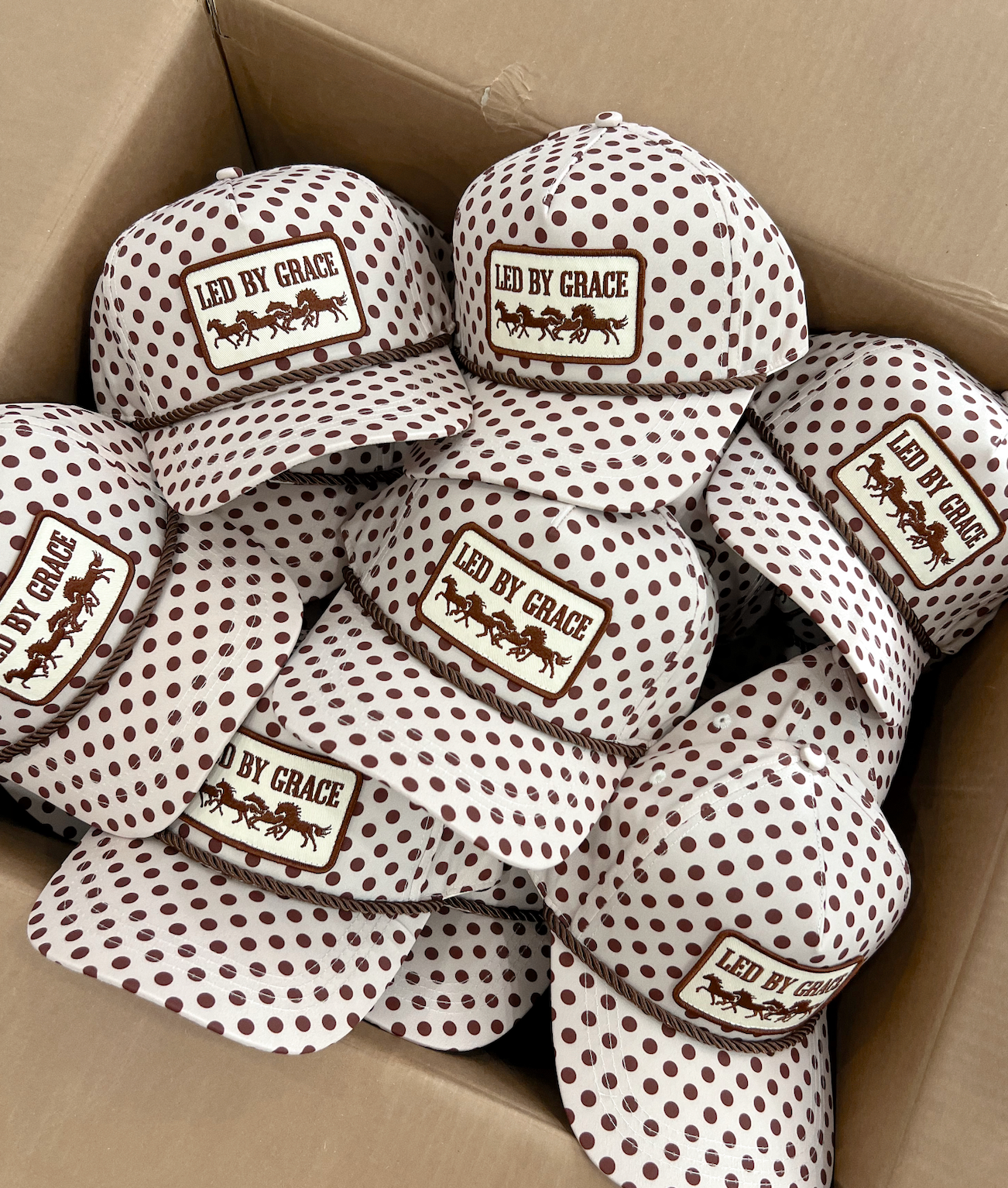 Led By Grace Cream & Brown Polka Dot Patch Hat — cream trucker hat with an allover brown polka dot print and brown rope