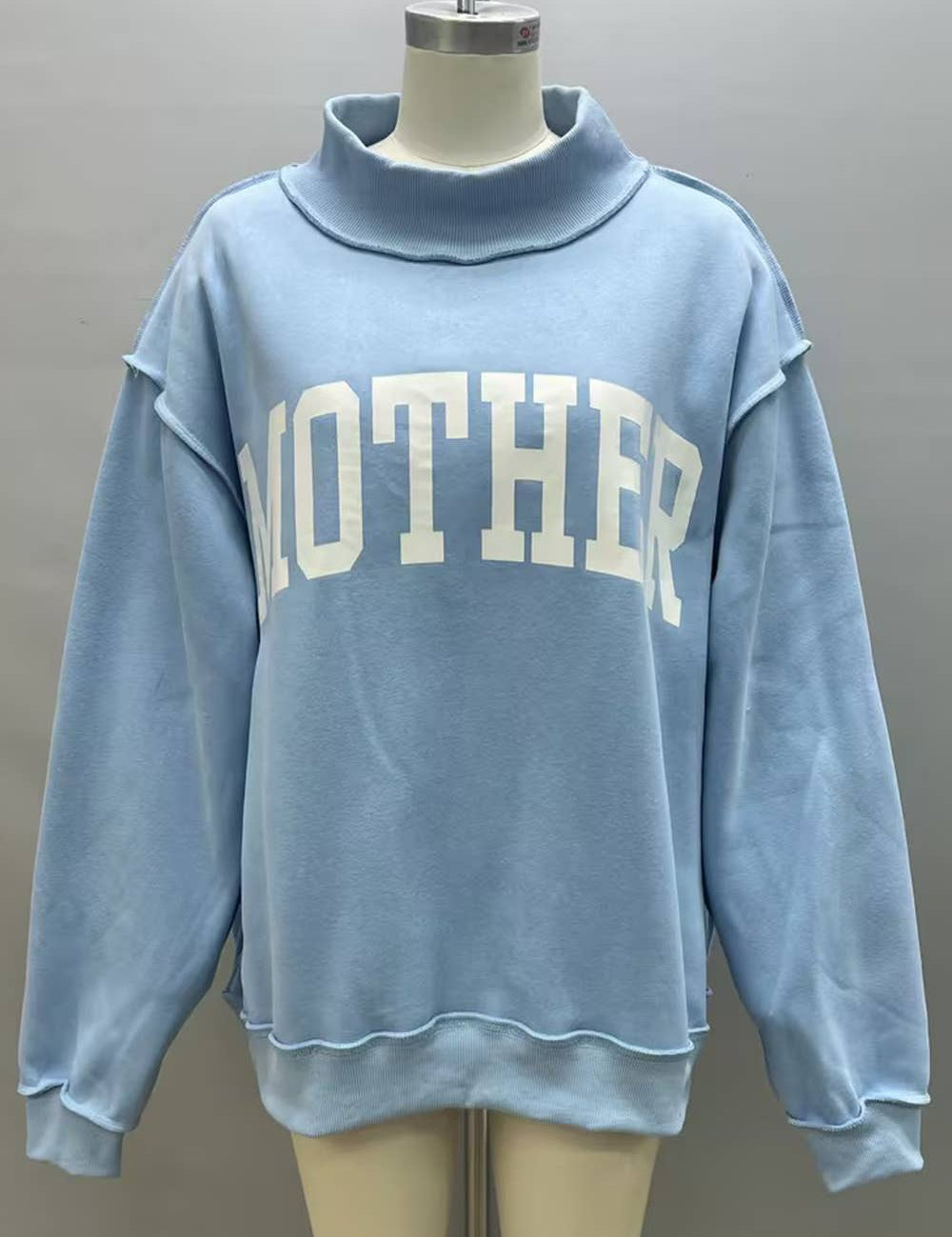 Blue Mother Reversible Mock Neck showing color: light blue with white lettering