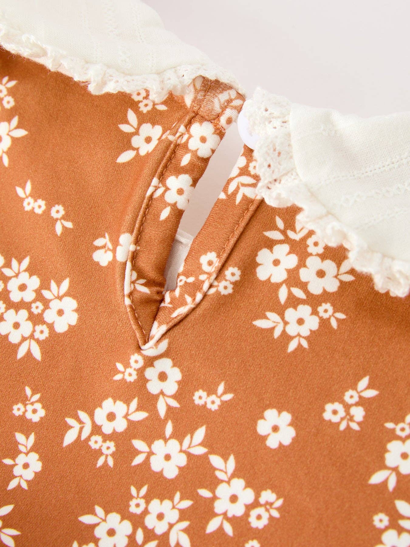 Rust Floral Bubble Romper showing bottom snaps