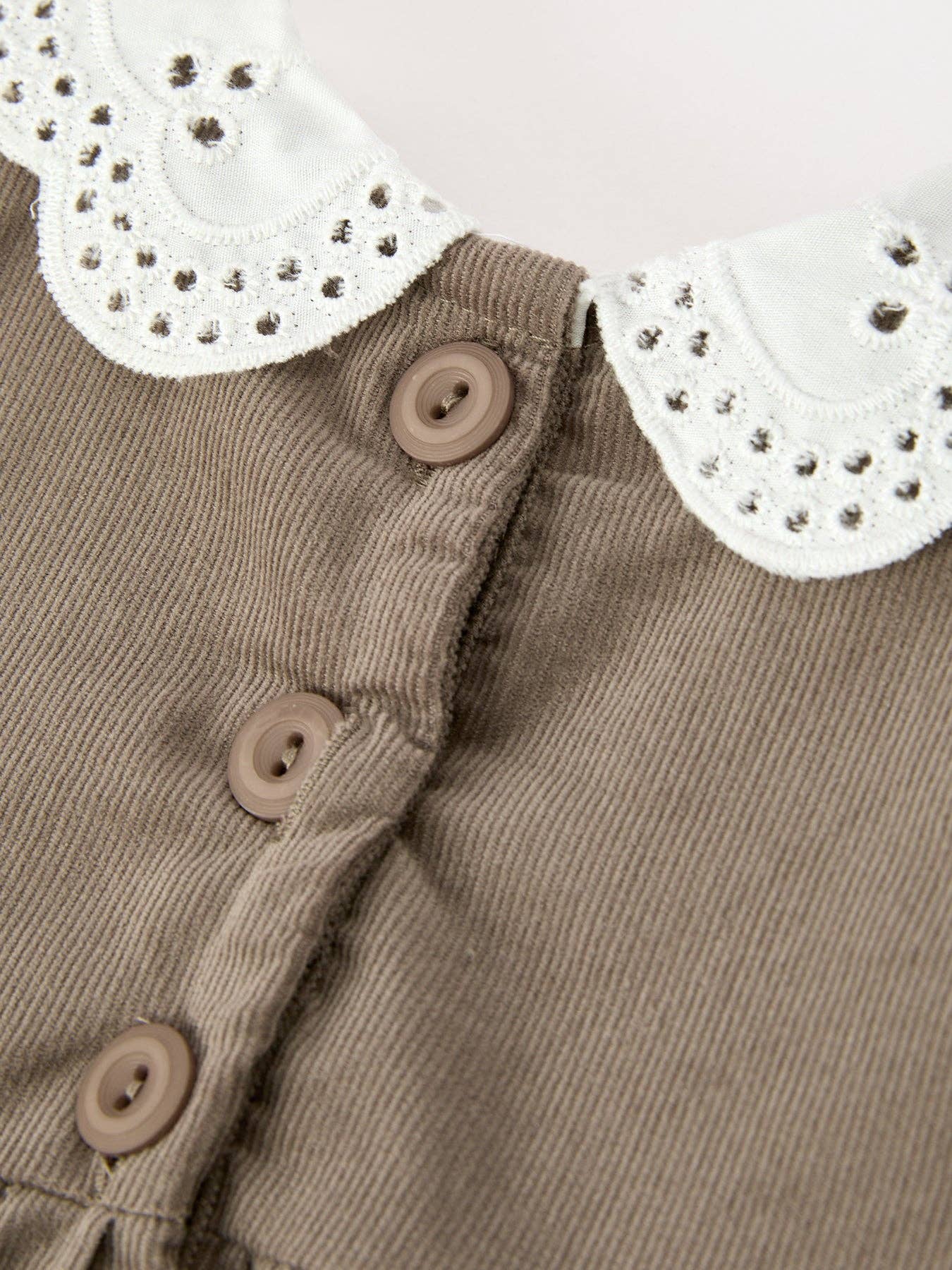 Pumpkin Smocked Eyelet Collar Romper showing elastic leg openings