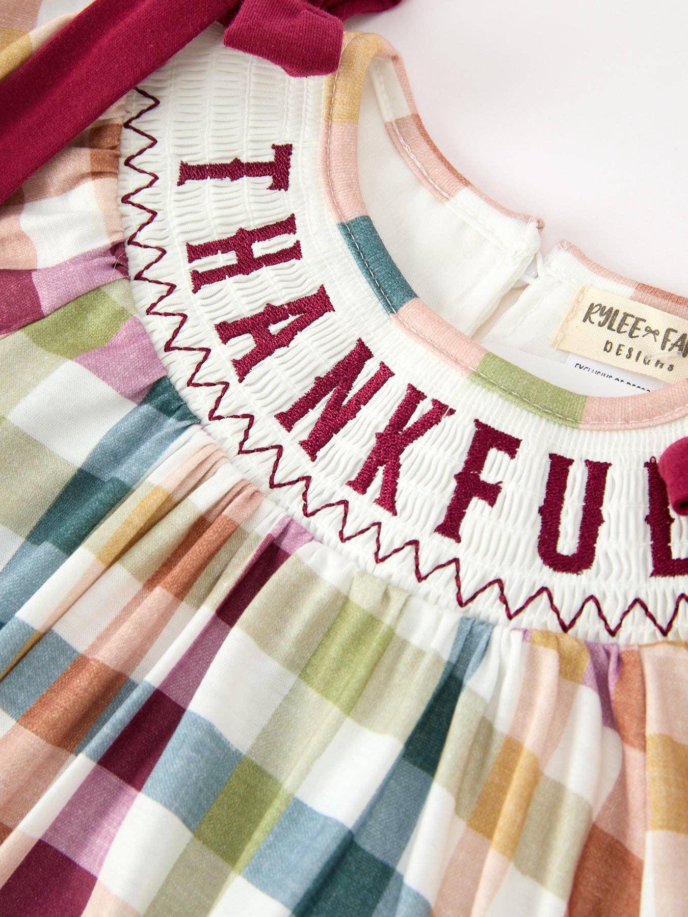 THANKFUL Smocked Plaid Bubble Romper showing long puff sleeves