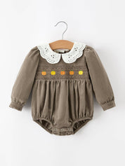 Pumpkin Smocked Eyelet Collar Romper — colorful pumpkin embroidery across the smocked chest and white eyelet peter pan collar