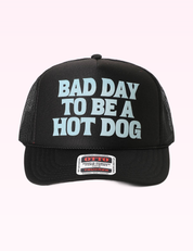 Ninety Nine Boutique super-pale pink accessory product photo: Black Bad Day To Be A Hot Dog Trucker Hat (September 30, 2026)