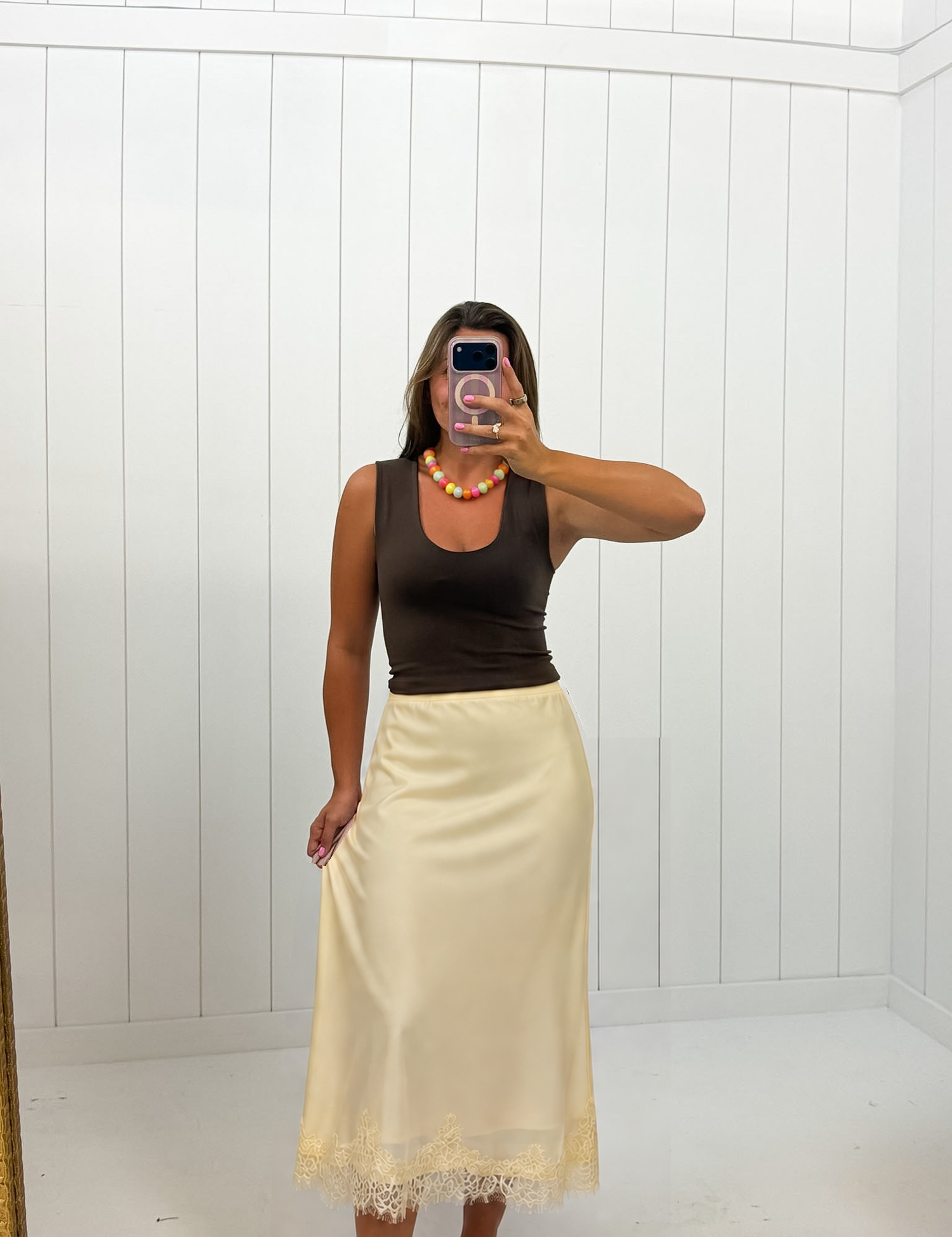 AI-assisted styled photo of Yellow Satin Midi Skirt on boutique owner, soft original-room lighting approved September 21 2026