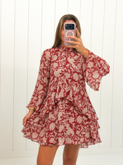 AI-assisted styled photo of Red Floral Neck Tie Mini Dress on boutique owner, soft original-room lighting approved September 21 2026
