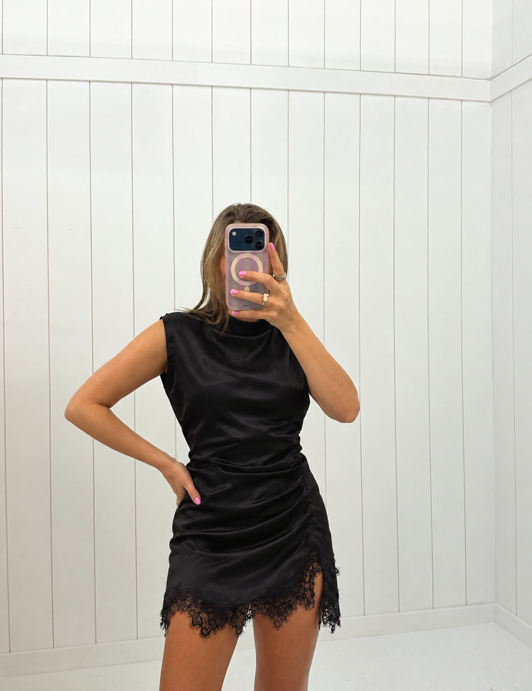 AI-assisted virtual try-on of Black Lace Trim Satin Mini Dress on boutique owner. Approved October 4, 2026; no-feet crop.