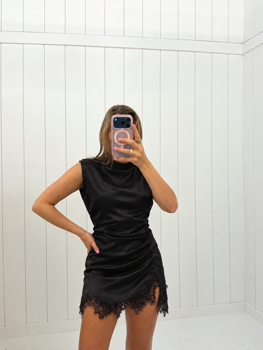 AI-assisted virtual try-on of Black Lace Trim Satin Mini Dress on boutique owner. Approved October 4, 2026; no-feet crop.