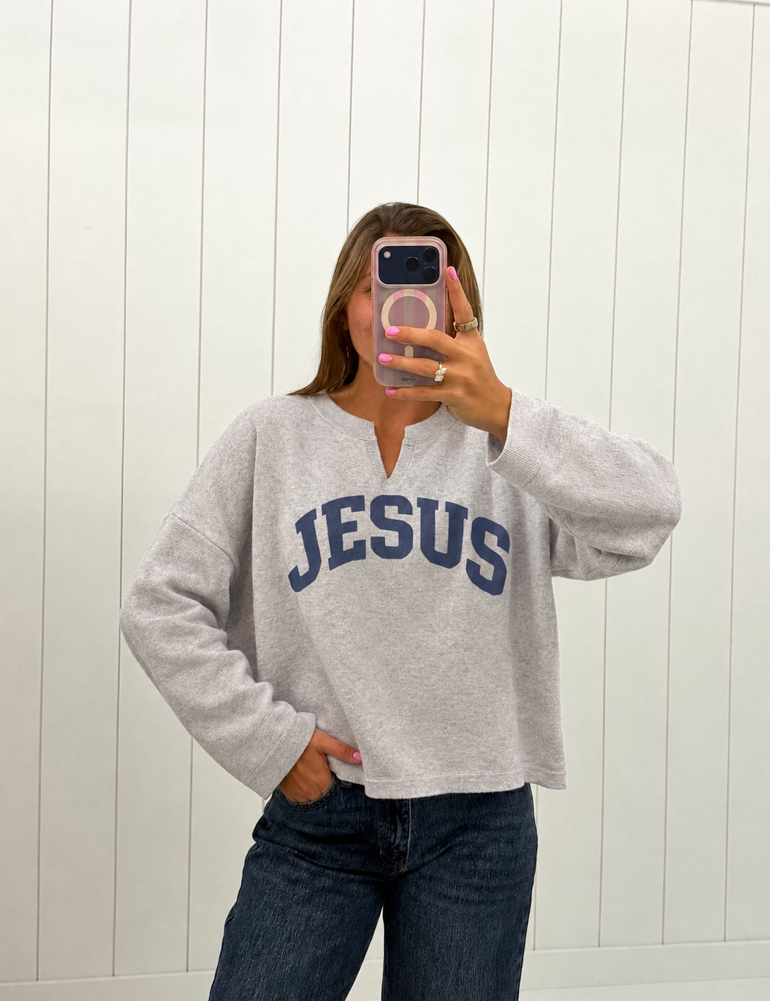 AI-assisted virtual try-on of Gray Jesus Split-Neck Sweatshirt on boutique owner. Approved October 4, 2026; no-feet crop.