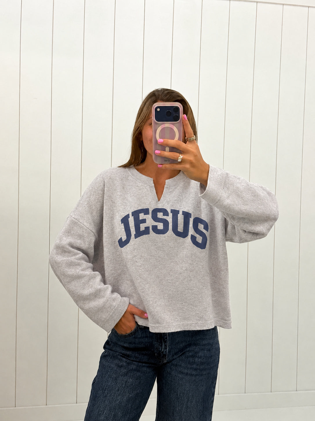 AI-assisted virtual try-on of Gray Jesus Split-Neck Sweatshirt on boutique owner. Approved October 4, 2026; no-feet crop.