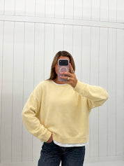 AI-assisted virtual try-on of Yellow Layered Crew Pullover on boutique owner. Approved October 4, 2026; no-feet crop.