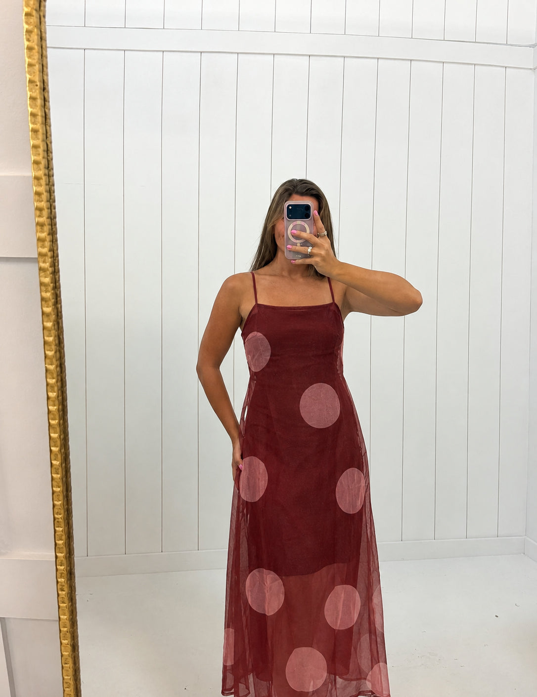 AI-assisted virtual try-on of Maroon Polka Dot Sheer Maxi Dress on boutique owner. Approved October 4, 2026; no-feet crop.