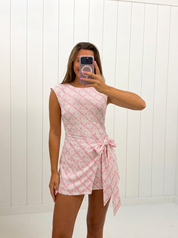 AI-assisted FASHN try-on of Pink Wrap Side Tie Detail Mini Dress on boutique owner.