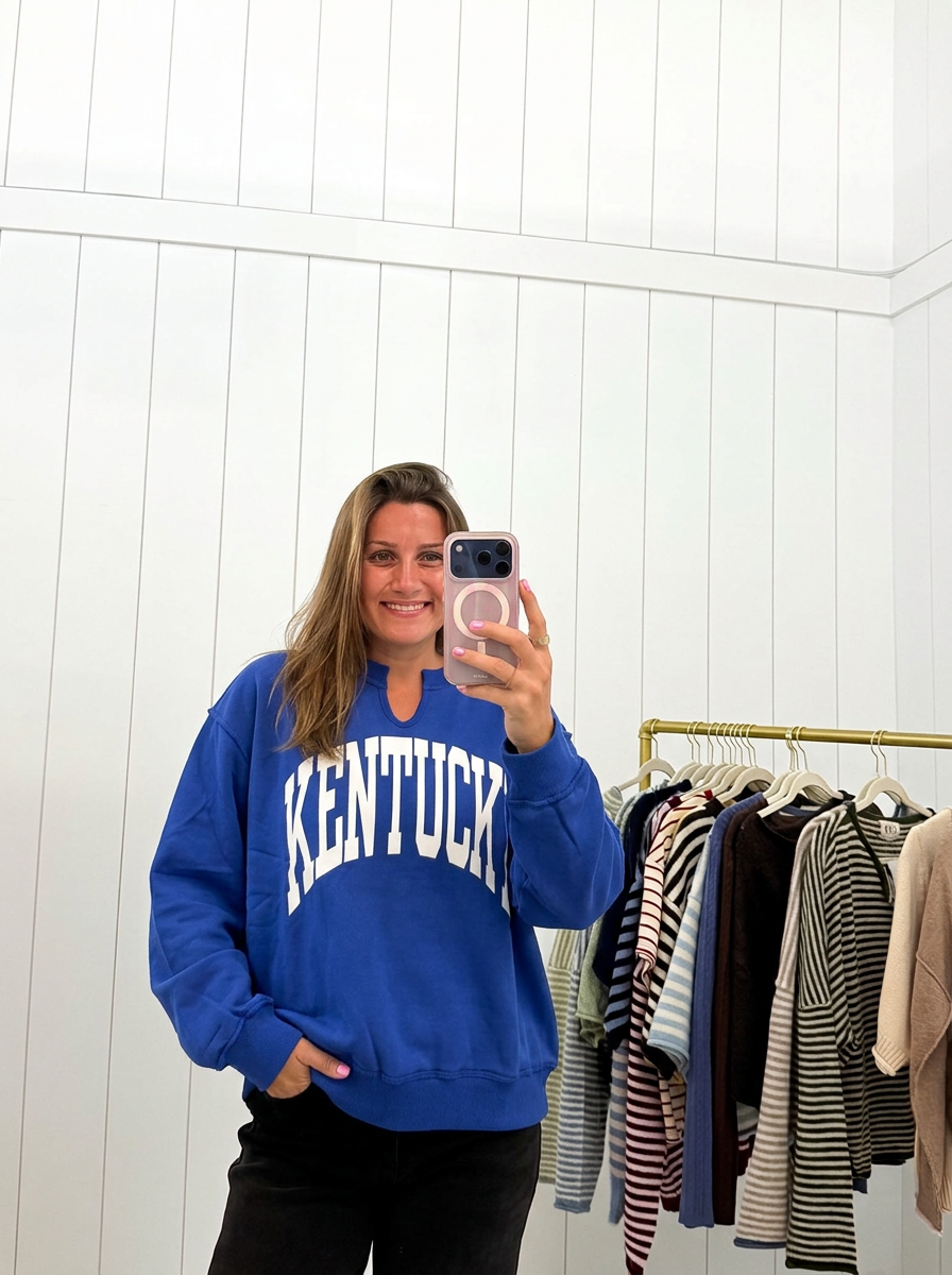AI-assisted FASHN try-on of Blue Kentucky Split-Neck Sweatshirt on boutique owner.