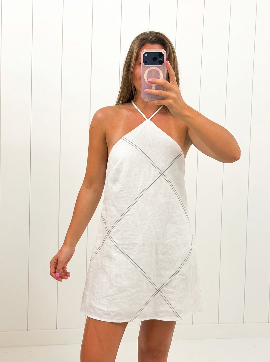 AI-assisted FASHN try-on of White Linen Stitch Mini Dress on boutique owner.