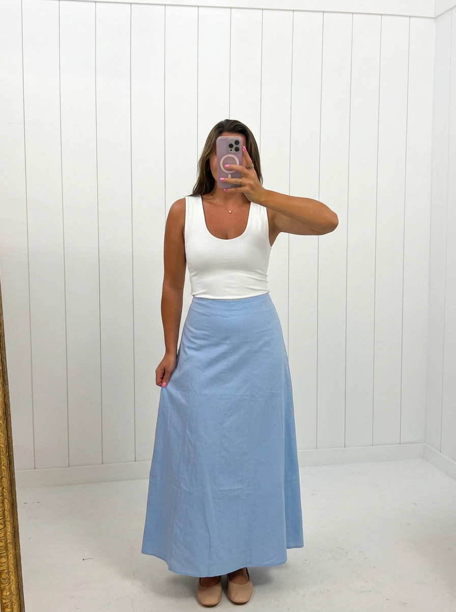 AI-assisted FASHN try-on of Blue Contrast Detail Maxi Skirt on boutique owner; approved September 24, 2026 redo using IMG_5221.jpeg.