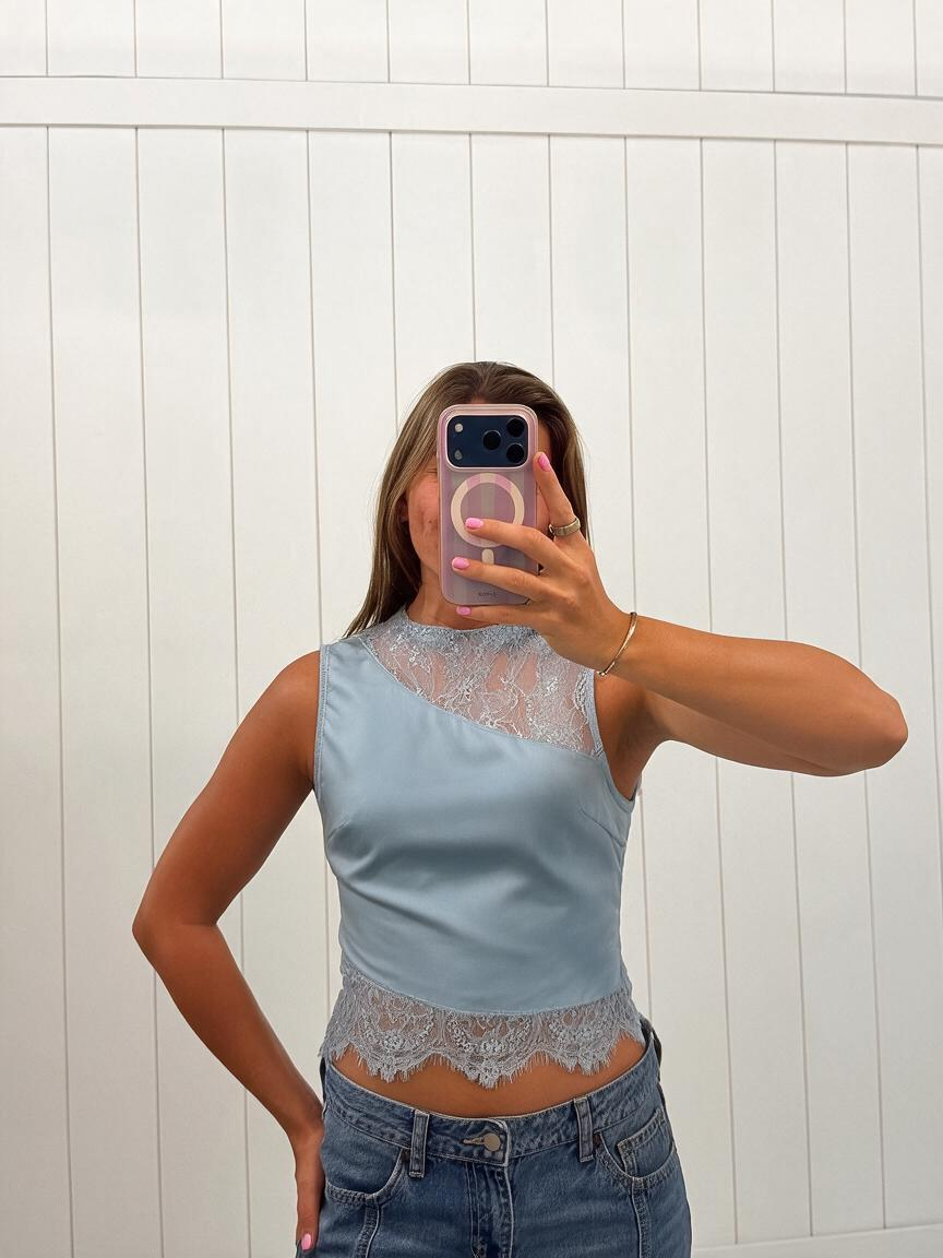 AI-assisted FASHN try-on of Blue Lace Sleeveless Top on boutique owner.