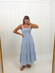 AI-assisted FASHN try-on of Blue & White Linen Striped Maxi on boutique owner.