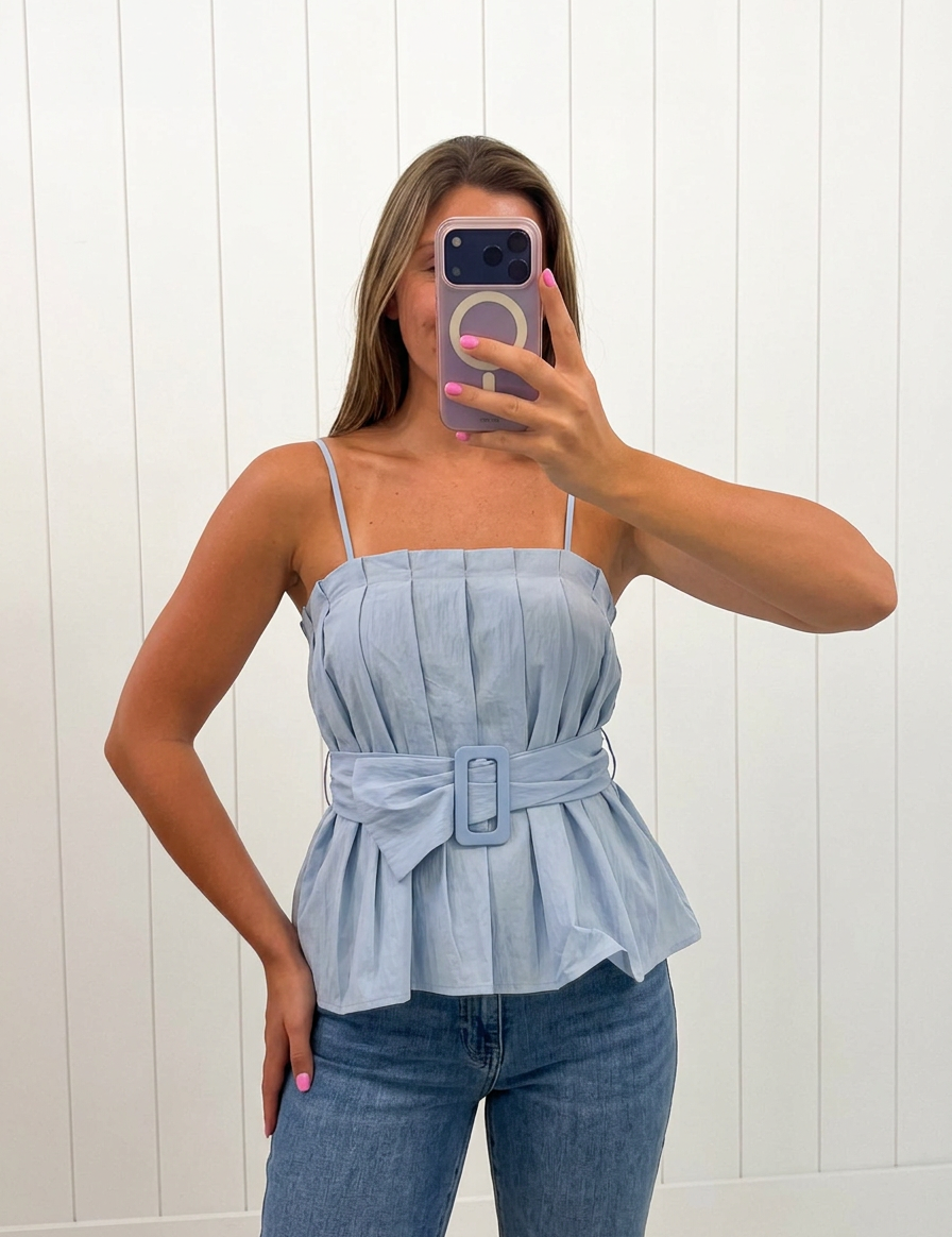 AI-assisted FASHN try-on of Blue Buckle Pleated Sleeveless Top on boutique owner.