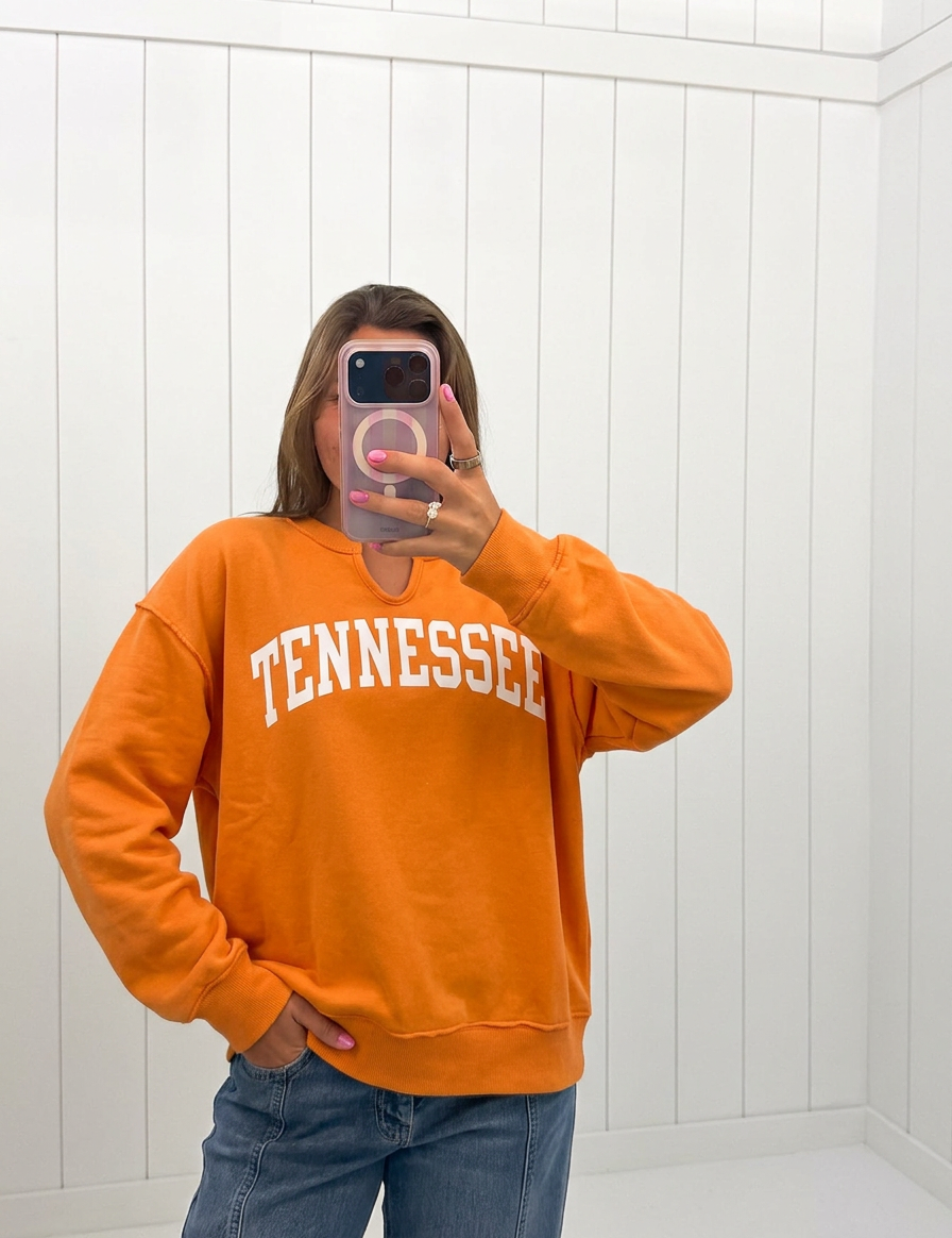 AI-assisted FASHN try-on of Orange Tennessee Split-Neck Sweatshirt on boutique owner.