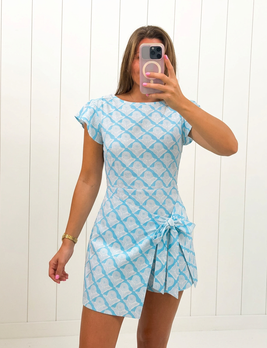 AI-assisted FASHN try-on of Blue Wrap Side Tie Detail Mini Dress on boutique owner.