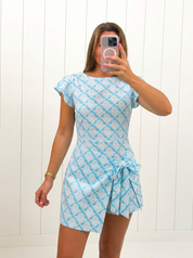 AI-assisted FASHN try-on of Blue Wrap Side Tie Detail Mini Dress on boutique owner.