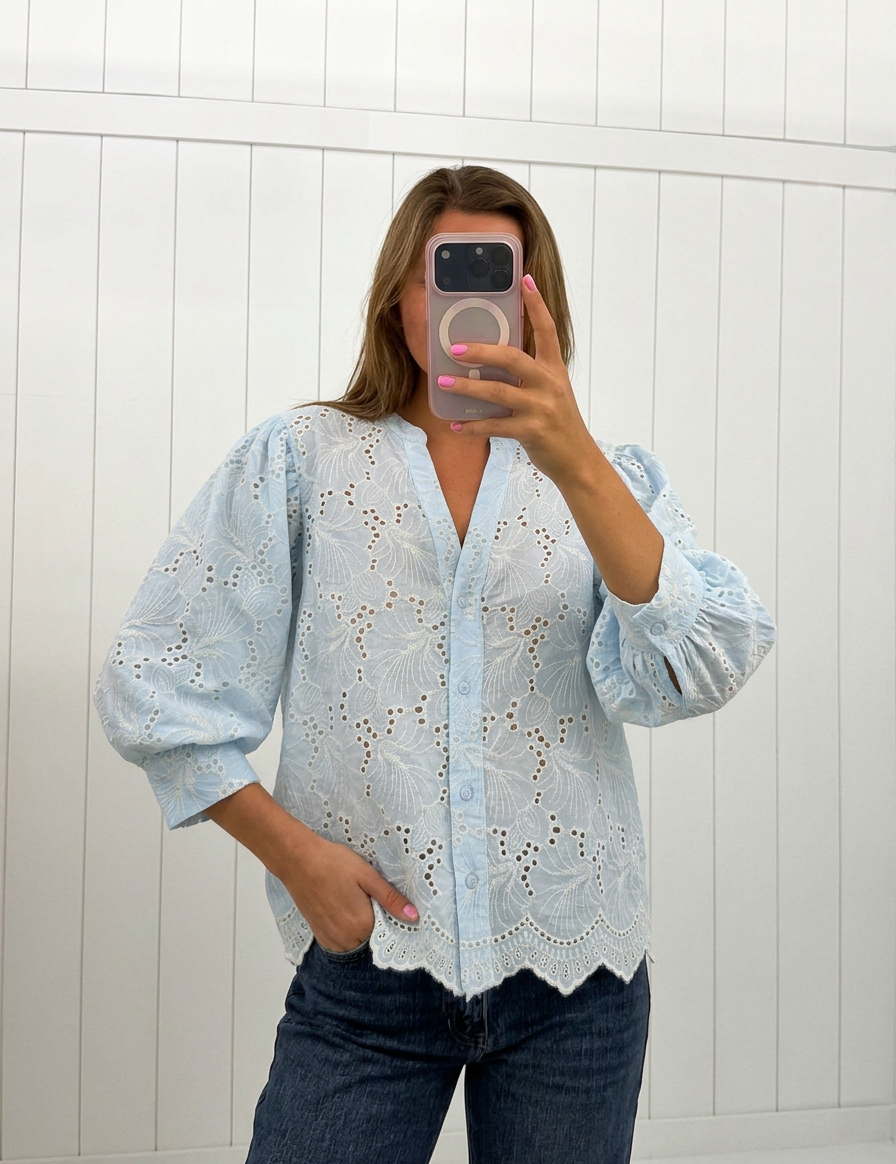 AI-assisted FASHN try-on of Blue Embroidered Eyelet Blouse on boutique owner.