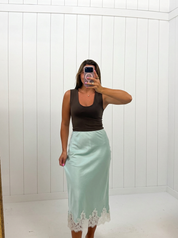AI-assisted FASHN try-on of Mint Satin Mid Skirt on boutique owner.